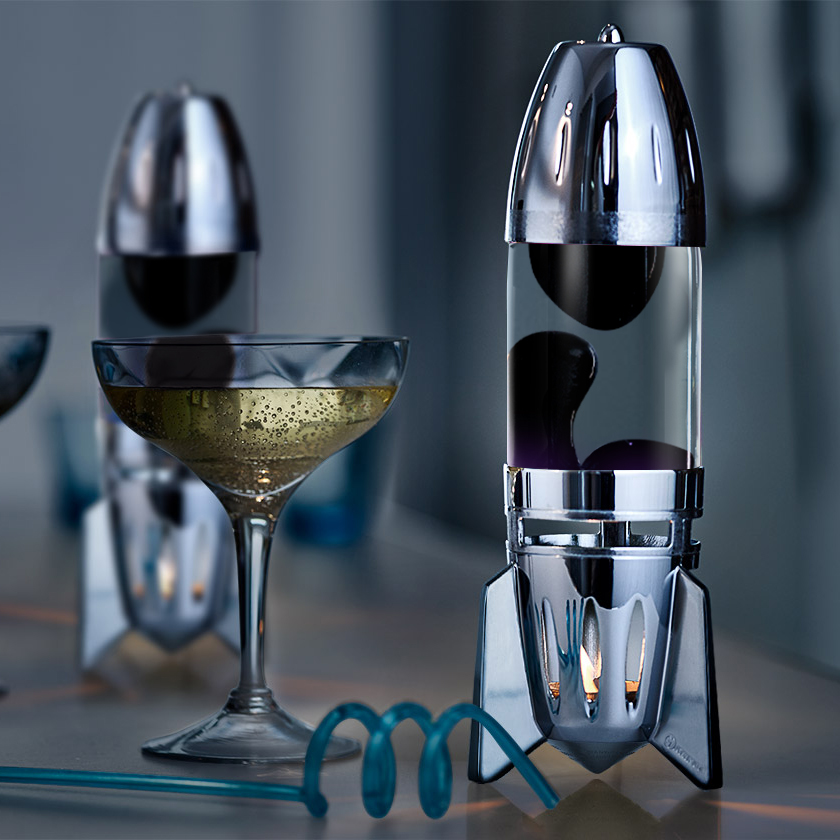 Mathmos Fireflow žvakinė lavos lempa su sidabriniu korpusu, skaidriu skysčiu ir juoda lava, modernus interjero akcentas ant stalo