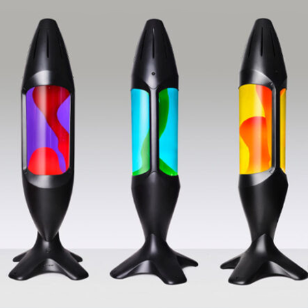 Originali Mathmos iO didelė lavos lempa – Juoda / Visos spalvos Trys juodos Mathmos iO lavos lempos su skirtingų spalvų skysčiu ir lava šviesiame fone